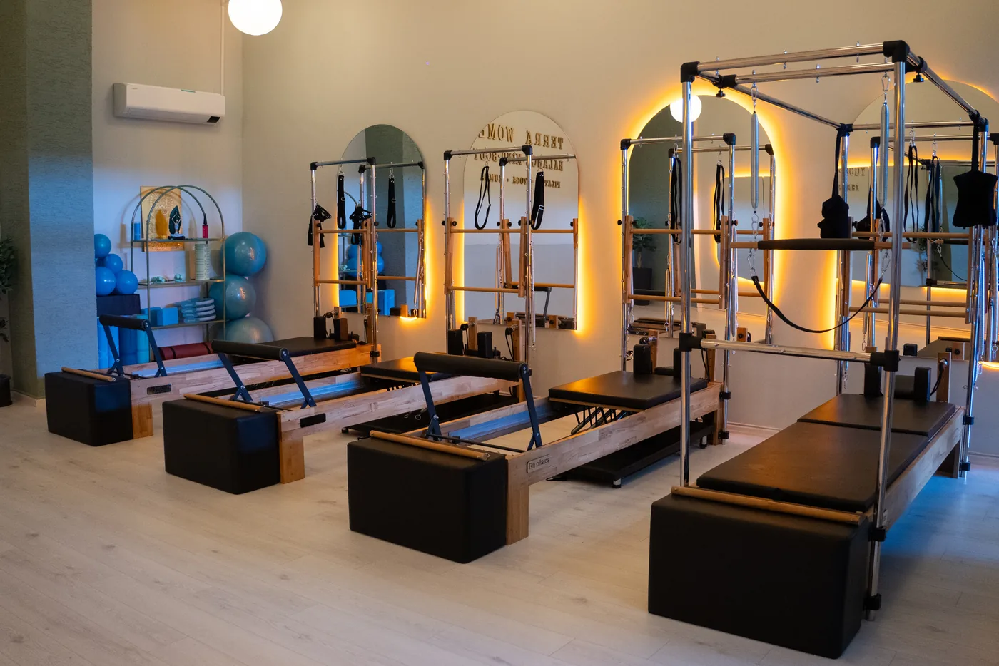 Terra Pilates stüdyosunda yan yana reformerlar, ışıklı aynalar ve egzersiz topları