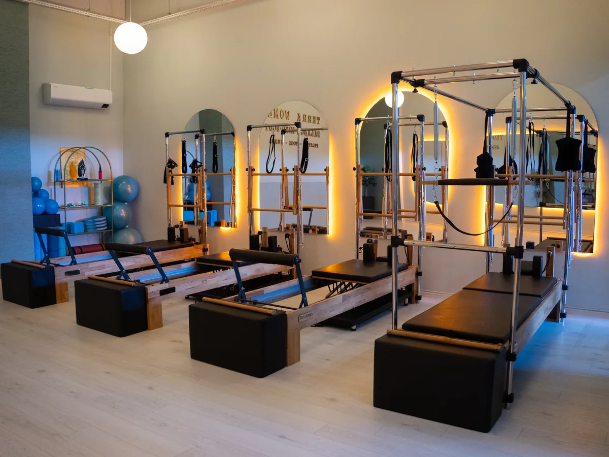 Aydınlatılmış aynalar ve reformer ekipmanlarıyla Terra Pilates stüdyosu
